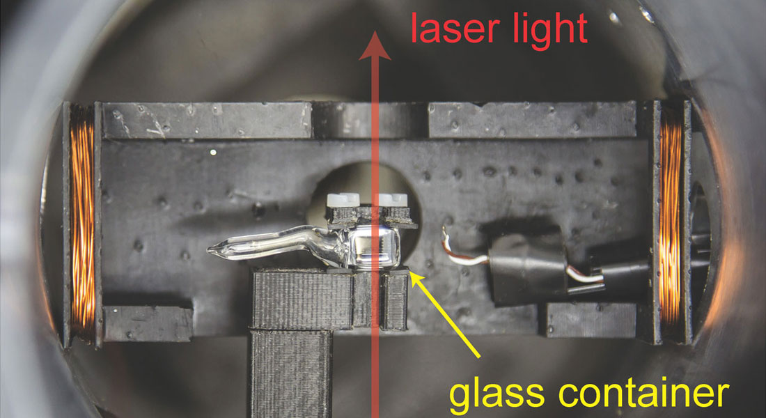 The glass container is filled with a gas of cesium atoms which respond to the magnetic field from the heart. The magnetic field is detected using laser light which is transmitted through the cesium atoms.