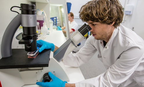 Silas Boye Nissen looking in microscope