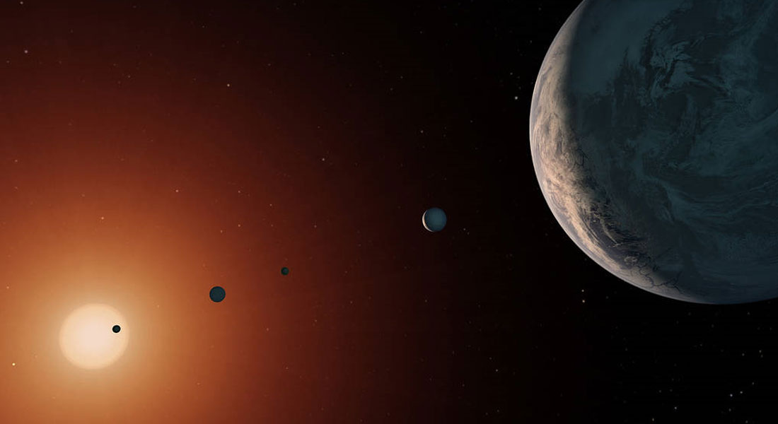 Illustrationen viser en kunstnerisk fremstilling af, hvordan solsystemet TRAPPIST-1 kunne se ud. Dets 7 planeter er alle af jord-størrelse og jordlignende og har potentiale til at have flydende vand, afhængigt af deres sammensætning. 