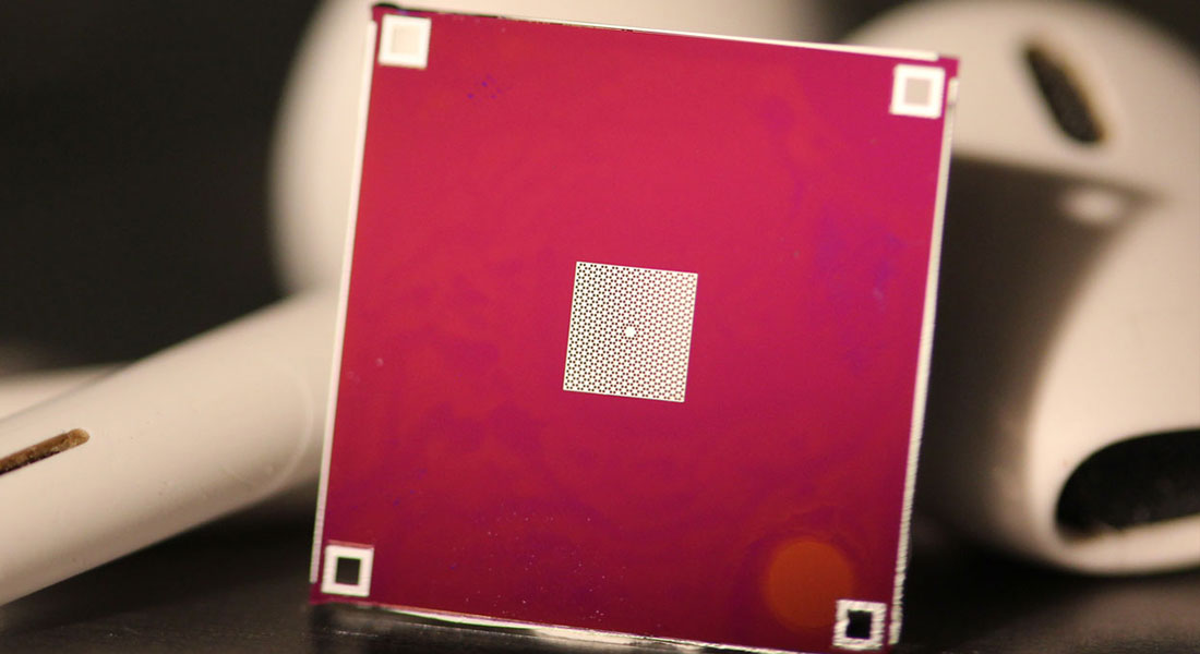 A thin silicon nitride membrane (white) is stretched tight across a silicon frame (red). The membrane contains a pattern of holes, with one small island in the center, whose vibrations are measured in the experiment. A thin silicon nitride membrane (white) is stretched tight across a silicon frame (red). The membrane contains a pattern of holes, with one small island in the center, whose vibrations are measured in the experiment.