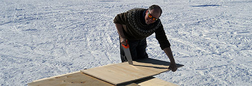 Field leader and amateur carpenter Sune cutting plywood for the kitchen furniture.